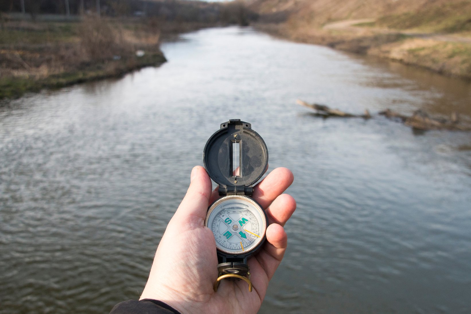 Hand with compass. Traveler searching direction.